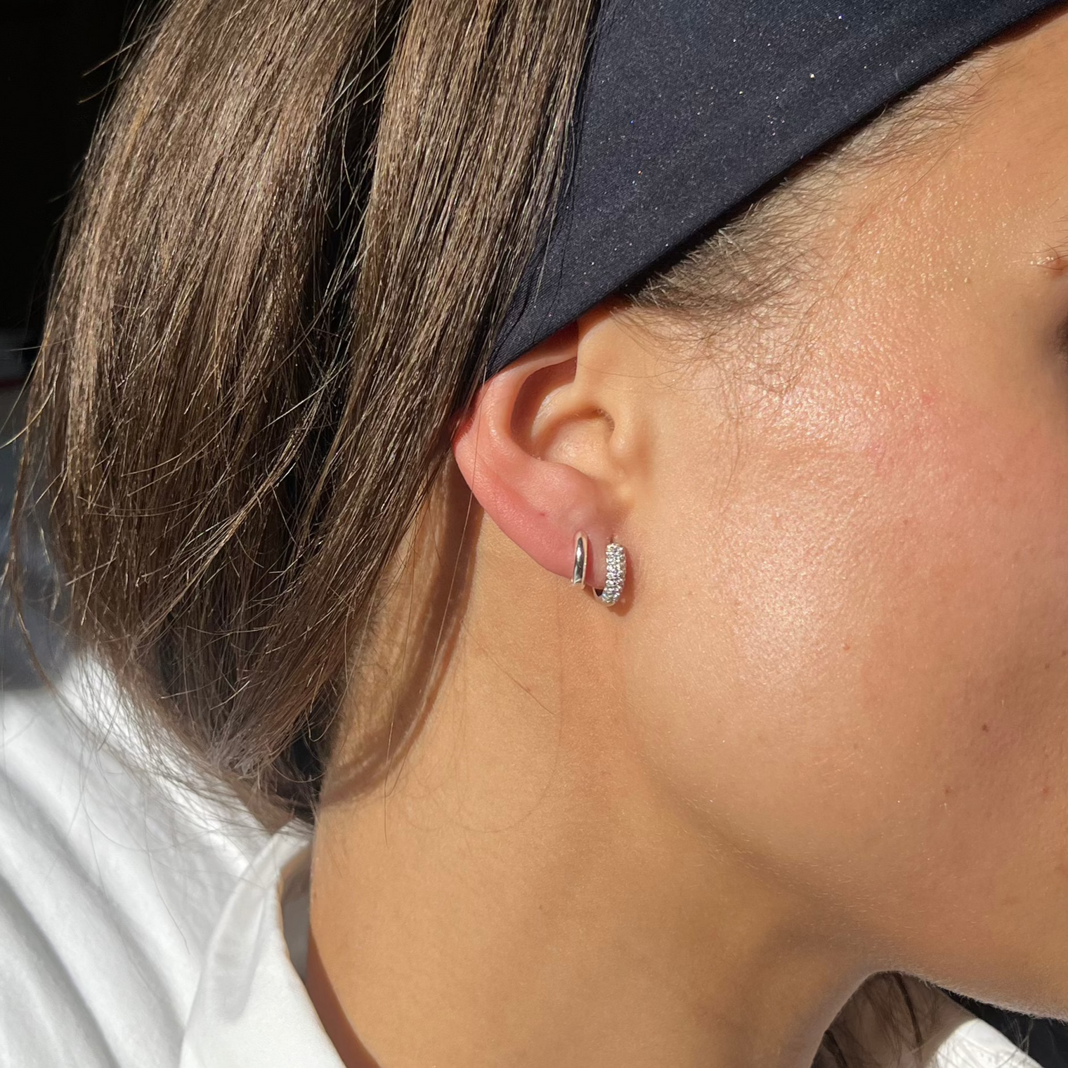 Small silver hoop earring set in ear