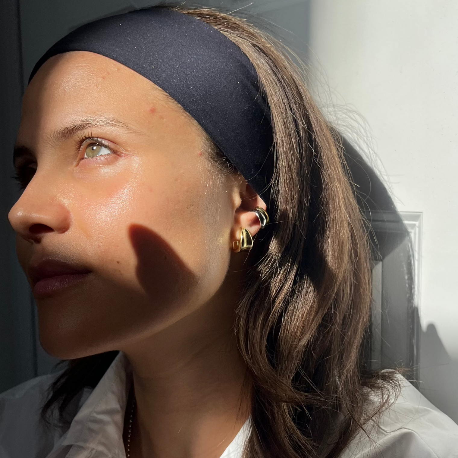 gold earrings in the sun with silver cuff and gold helix cuff