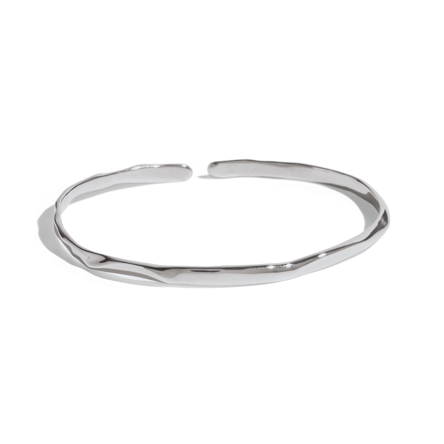 silver cuff bracelet with a slim, uneven design, offering a minimalist and modern look. This jewelry packshot showcases the bracelet's unique texture and open-ended style