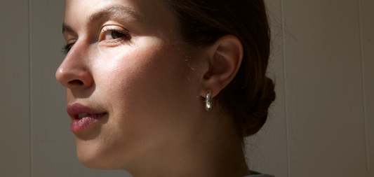 Silver hoop earrings. Bold earrings for everyday wear. Girl in sunlight with bold silver earrings.