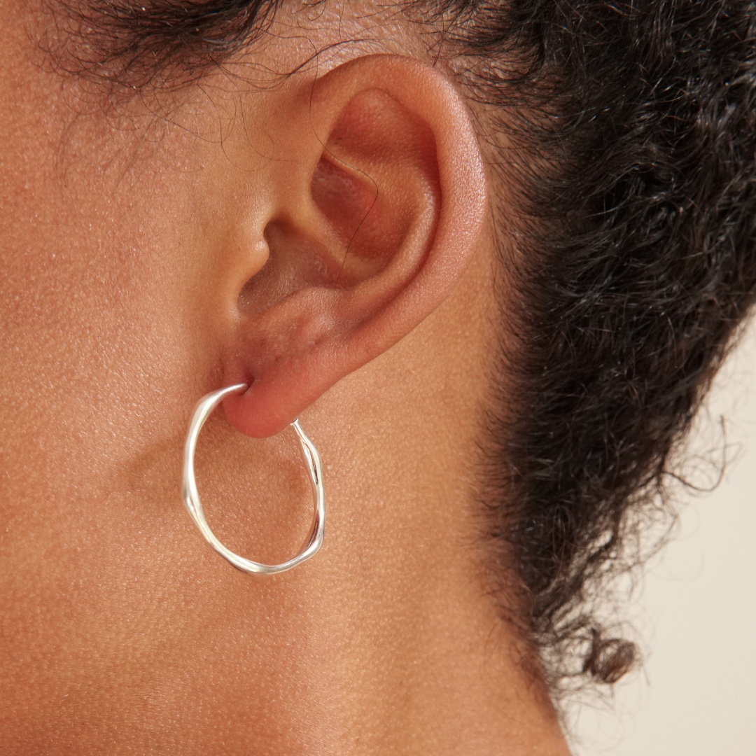 Silver hoop earring with uneven design